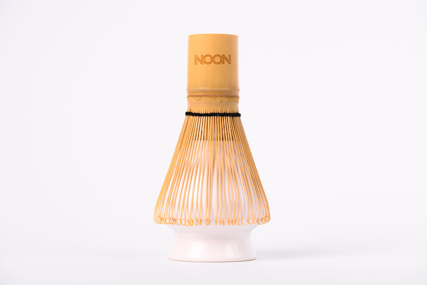 Gaiši brūna matcha bambusa slotiņa ar NOON logo uzlikta uz slotiņas turētāja