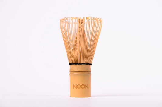 Gaiši brūna matcha bambusa slotiņa ar NOON logo uz balta fona