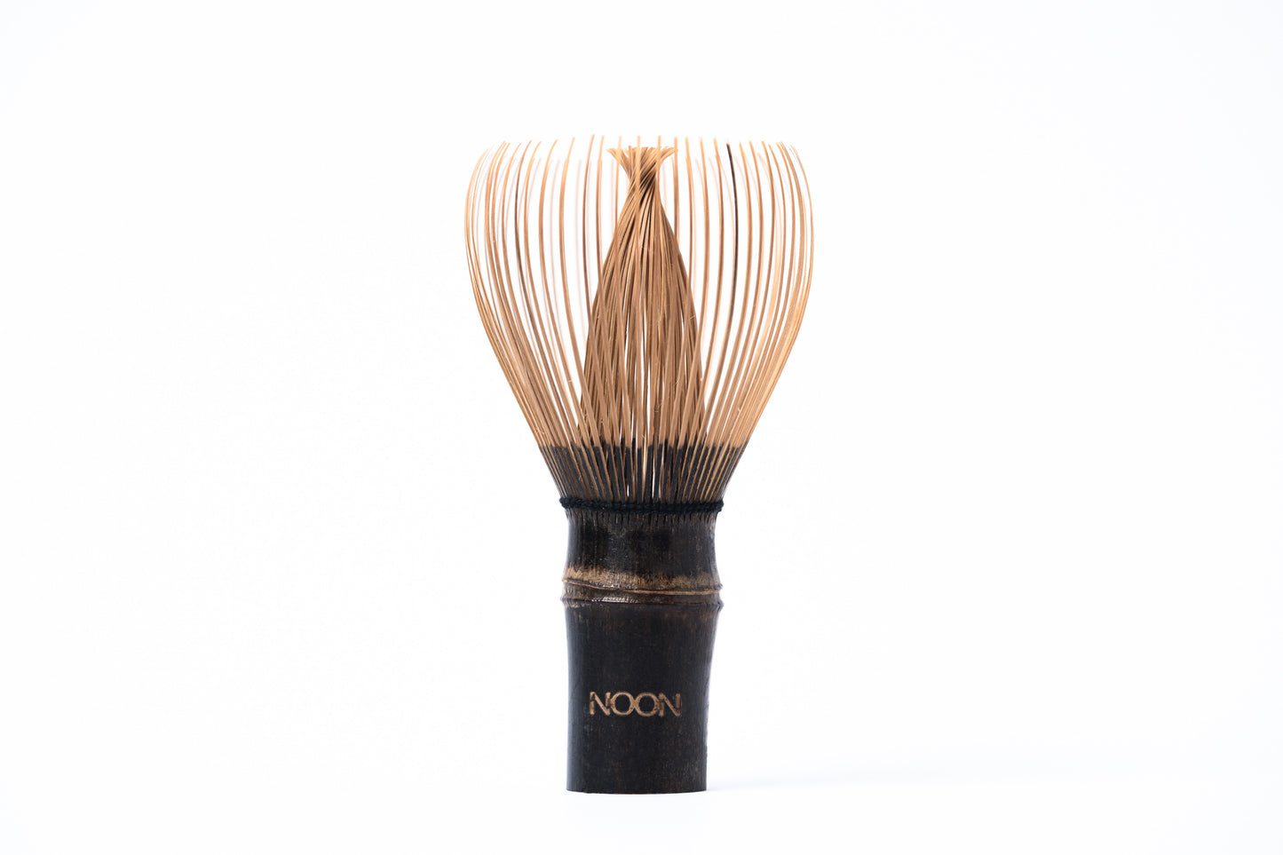 Tumši brūna bambusa matcha slotiņa ar sariem uz augšu un NOON logo.