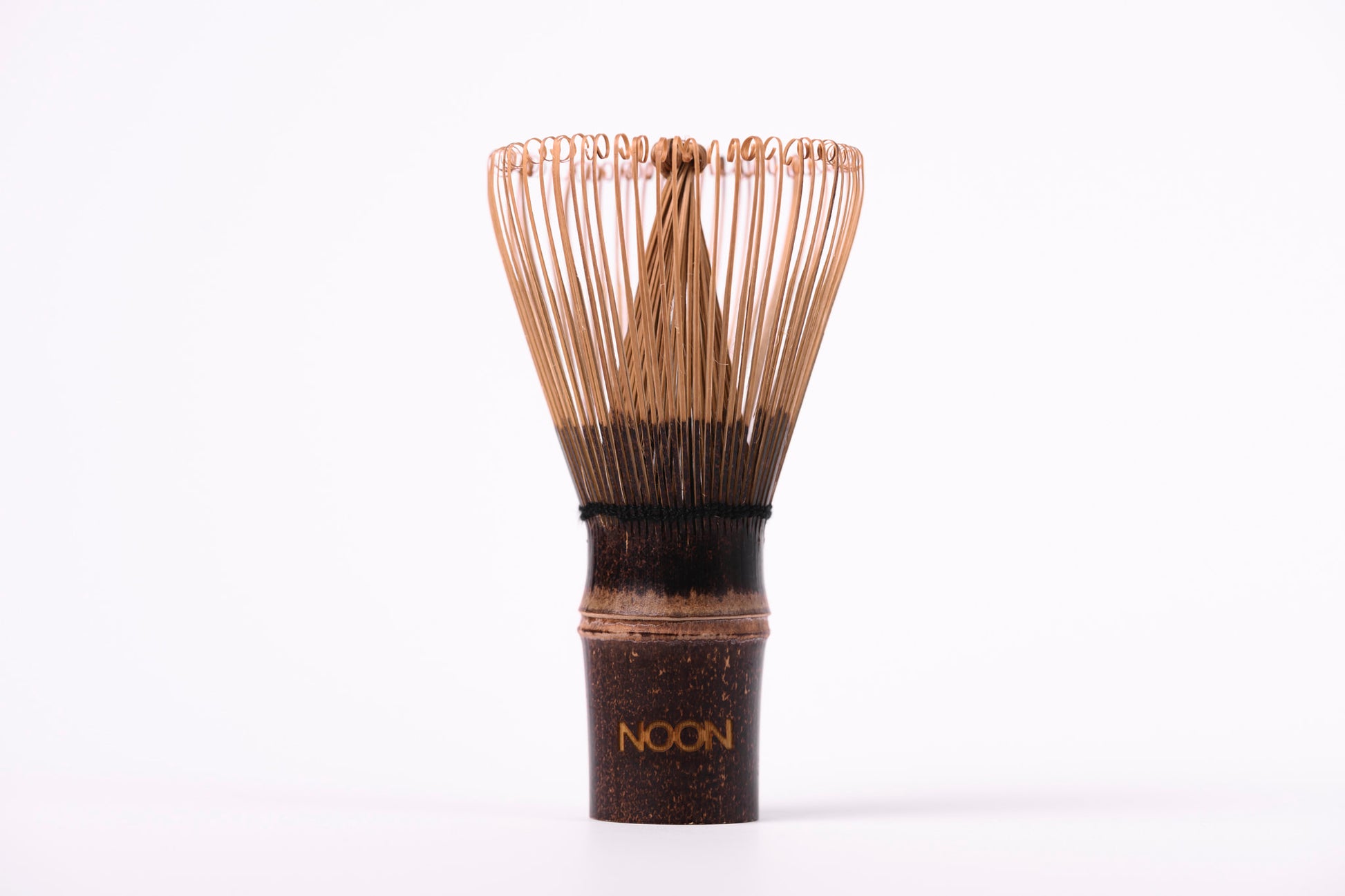 Tumši brūna matcha bambusa slotiņa ar NOON logo uz balta fona