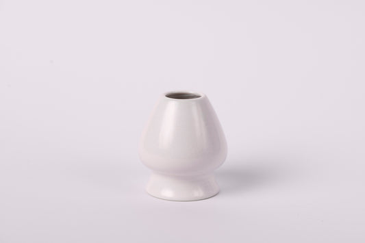 Krēmīgi balts keramisks matcha slotiņas turētājs uz balta fona